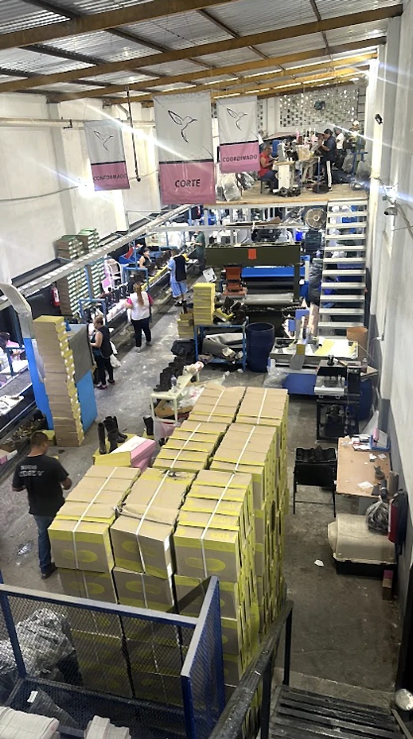 Overview of the factory floor: cutting and lasting areas, with stacked shoe boxes